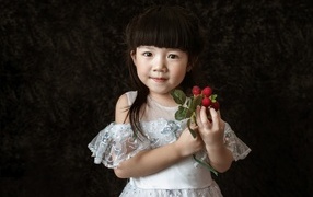 Девочка азиатка в белом платье с ягодами в руке