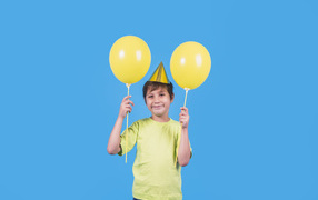 Мальчик на день рождения с желтыми шариками
