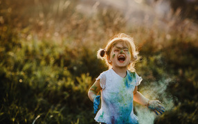 Веселая девочка в краске на улице