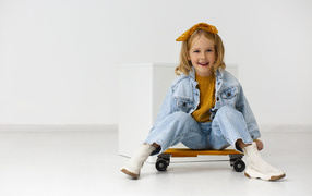 Cheerful girl on a skateboard in the room