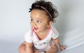 Веселая маленькая девочка с ободком на голове