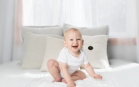 Смешной маленький ребенок на кровати