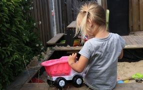 Девочка играет с игрушечной машинкой