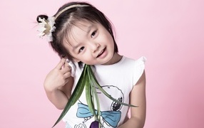 Маленькая девочка азиатка на розовом фоне