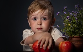 Маленький голубоглазый мальчик с яблоками
