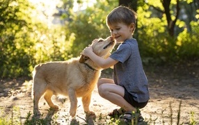 Маленький мальчик обнимает собаку