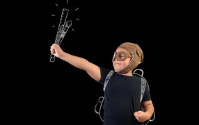 Маленький мальчик с нарисованными кистями на черном фоне