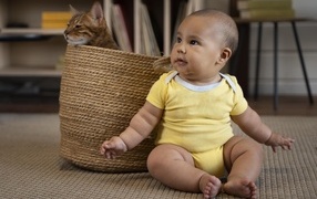 Маленький забавный ребенок с котом в корзине