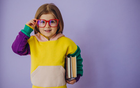 Little girl in glasses with books in hand