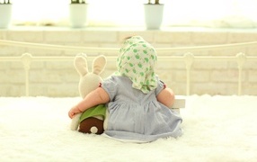 Маленькая девочка сидит с игрушкой