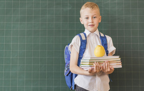 Мальчик школьник с книгами у доски