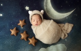 Спящий новорожденный ребенок с декором для фото 