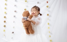 Улыбающаяся девочка азиатка с игрушечным медведем