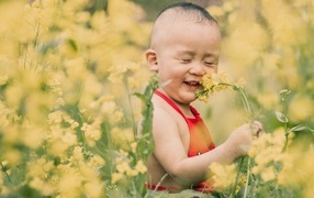 Улыбающийся ребенок на поле с желтыми цветами