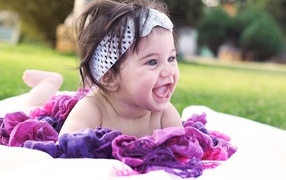 Улыбающаяся маленькая девочка с повязкой на голове 