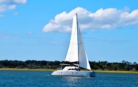 Парусная яхта в море на фоне красивого неба