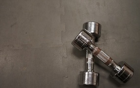 Две железные гантели на сером фоне