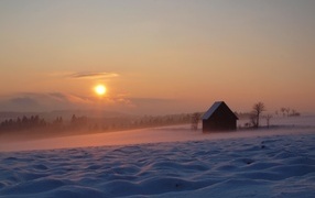 Cold winter sun setting over a snowy plain