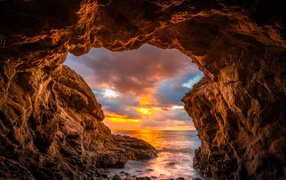 Arch in the mountain at sunset on Malibu beach, USA