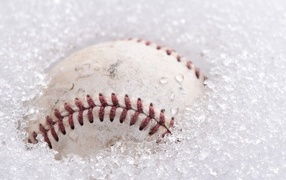 Бейсбольный мяч лежит в белом снегу