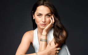 Актриса Ана де Армас с украшениями на руках на сером фоне