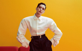 Актриса Энн Хэтэуэй в белой рубашке на желтом фоне