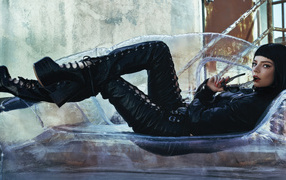 Актриса Аня Тейлор-Джой в черном костюме лежит на диване