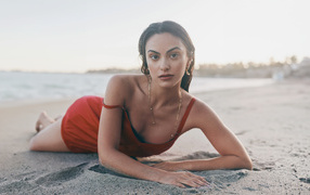 Актриса Камила Мендес лежит на песке на пляже