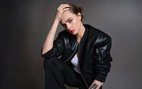 Актриса Кара Делевинь в черной кожаной куртке на сером фоне