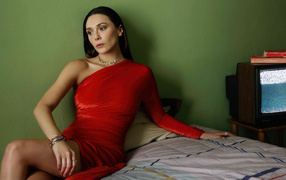 Актриса Элизабет Олсен в красном платье сидит на кровати