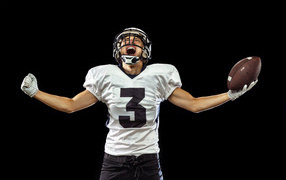 Игрок в американский футбол с мячом в руке