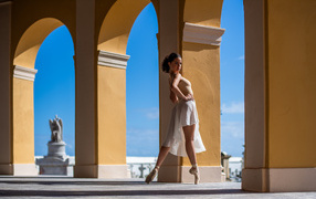 Девушка балерина в стойке у арки