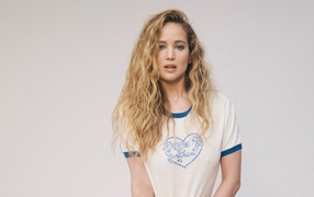 Блондинка актриса Дженнифер Лоуренс в футболке на сером фоне