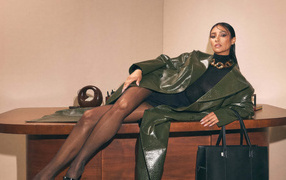 Канадская актриса Шэй Митчелл в плаще лежит на столе