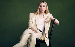 Милая актриса Дакота Фэннинг в костюме сидит на стуле