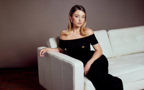 Милая девушка Сидни Суини в черном платье на диване