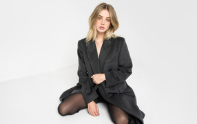 Знаменитая India Woollard в черном плаще на белом фоне