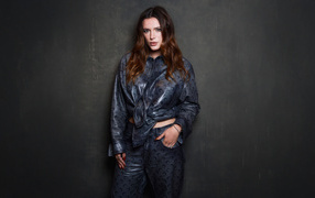 Рыжеволосая американская актриса Белла Торн в костюме на сером фоне