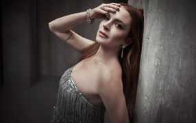 Рыжеволосая актриса Линдси Лохан стоит у стены