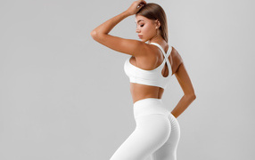 Стройная спортивная девушка в белом костюме