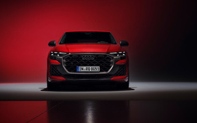 Вид спереди на автомобиль Audi RS Q8 performance 2024 года на красном фоне