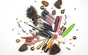 Много женской косметики на белом фоне с сосновыми шишками