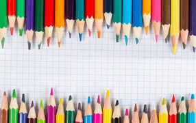 Заточенные карандаши на листе бумаги в клеточку