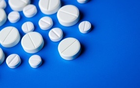 Белые таблетки на синем фоне