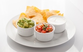 Чипсы с соусом на большой белой тарелке