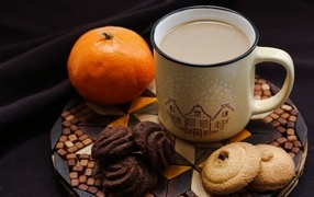 Чашка какао на тарелке с мандарином и печеньем