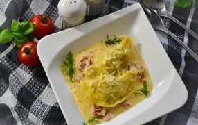 Равиоли с соусе с беконом на тарелке