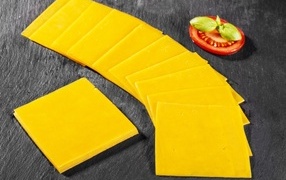 Ломтики сыра с помидором на столе