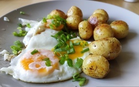 Молодая жареная картошка с яичницей и зеленым луком
