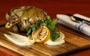 Артишок с лимоном на доске